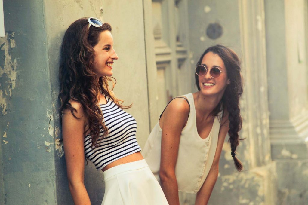 two young women laughing outside building